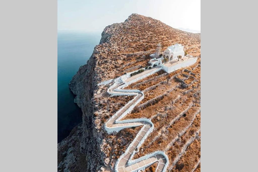 a road on the side of a mountain at Family house by the seaside of Karavostasis in Karavostasi