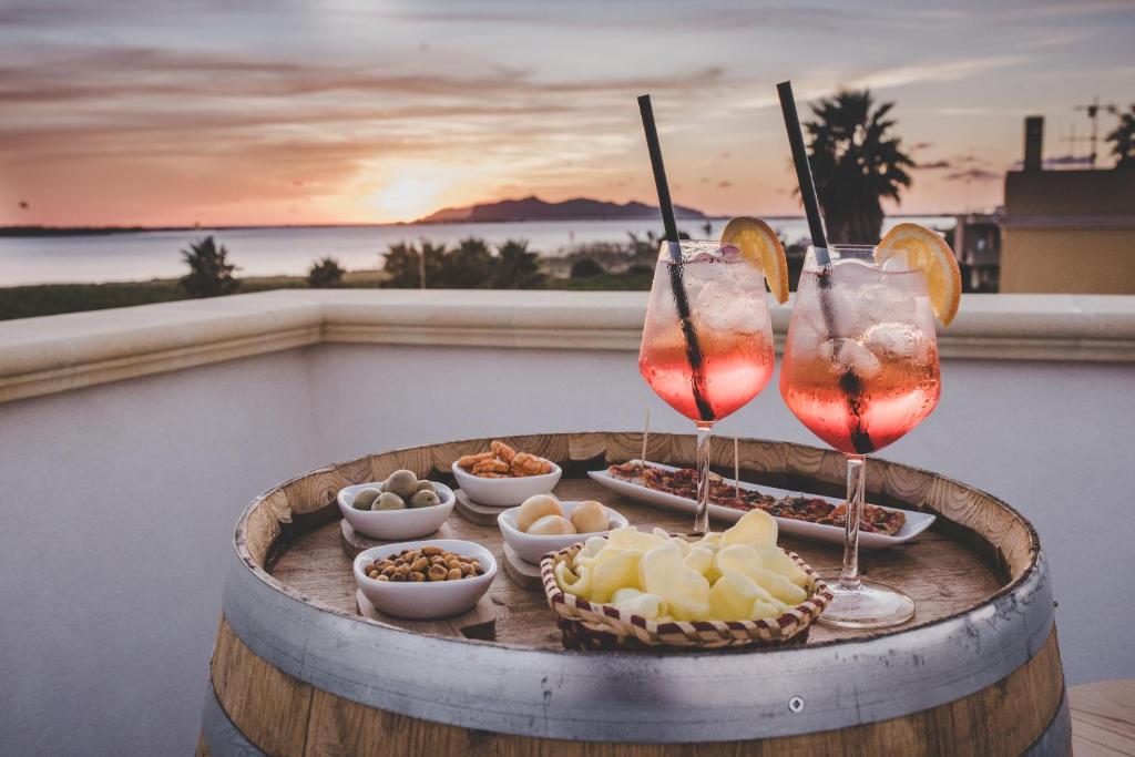 - une table avec 2 verres à vin et des collations sur un tonneau dans l'établissement Stella Fenicia, à Marsala