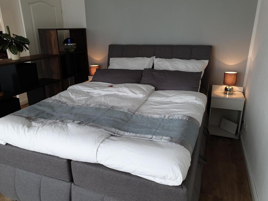 a bedroom with a large bed with white sheets at Deine Auszeit in Kiel