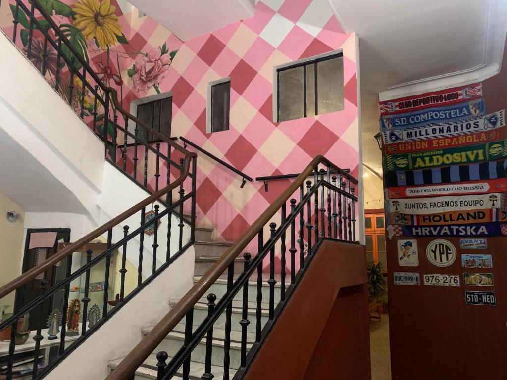 een trap met een roze en witte geruite muur bij Hostelmo Hotel in Buenos Aires