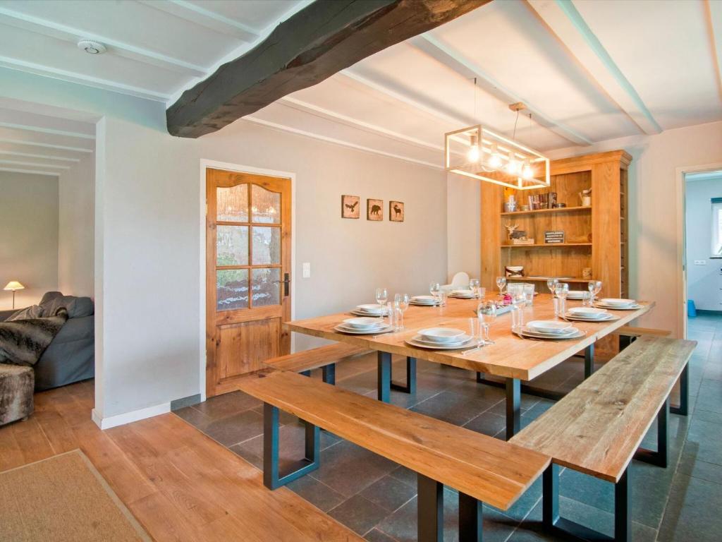 een eetkamer met een houten tafel en banken bij Holiday Home in Xhoffraix between Spa and Eifel Nature Park in Xhoffraix
