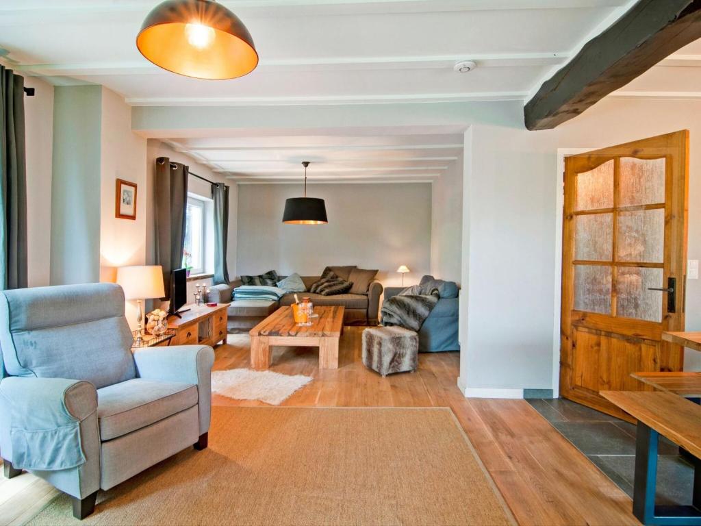a living room with a couch and a chair at Holiday Home between Spa and Eifel Nature Park in Xhoffraix