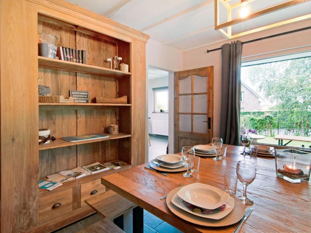 a dining room with a wooden table with plates and wine glasses at Holiday Home between Spa and Eifel Nature Park in Xhoffraix