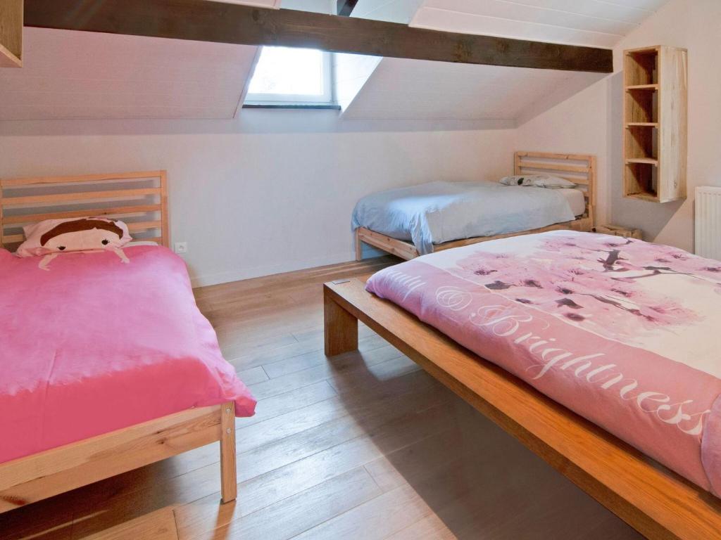 a bedroom with two beds and a wooden floor at Holiday Home between Spa and Eifel Nature Park in Xhoffraix
