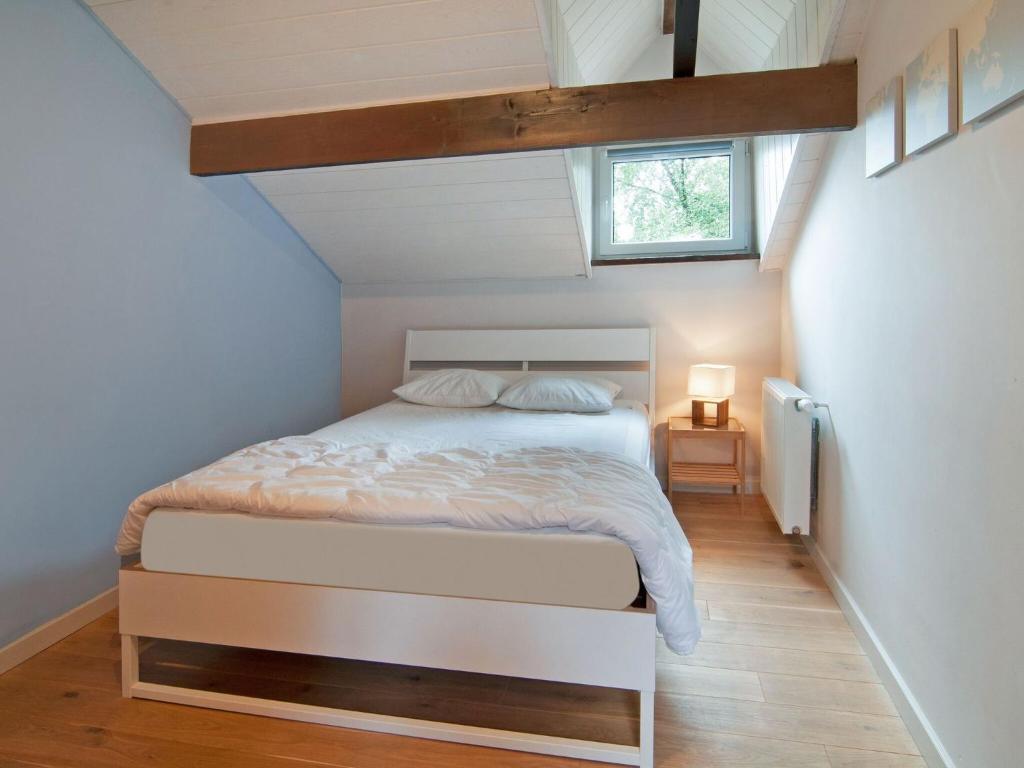 a bedroom with a white bed in a attic at Holiday Home between Spa and Eifel Nature Park in Xhoffraix
