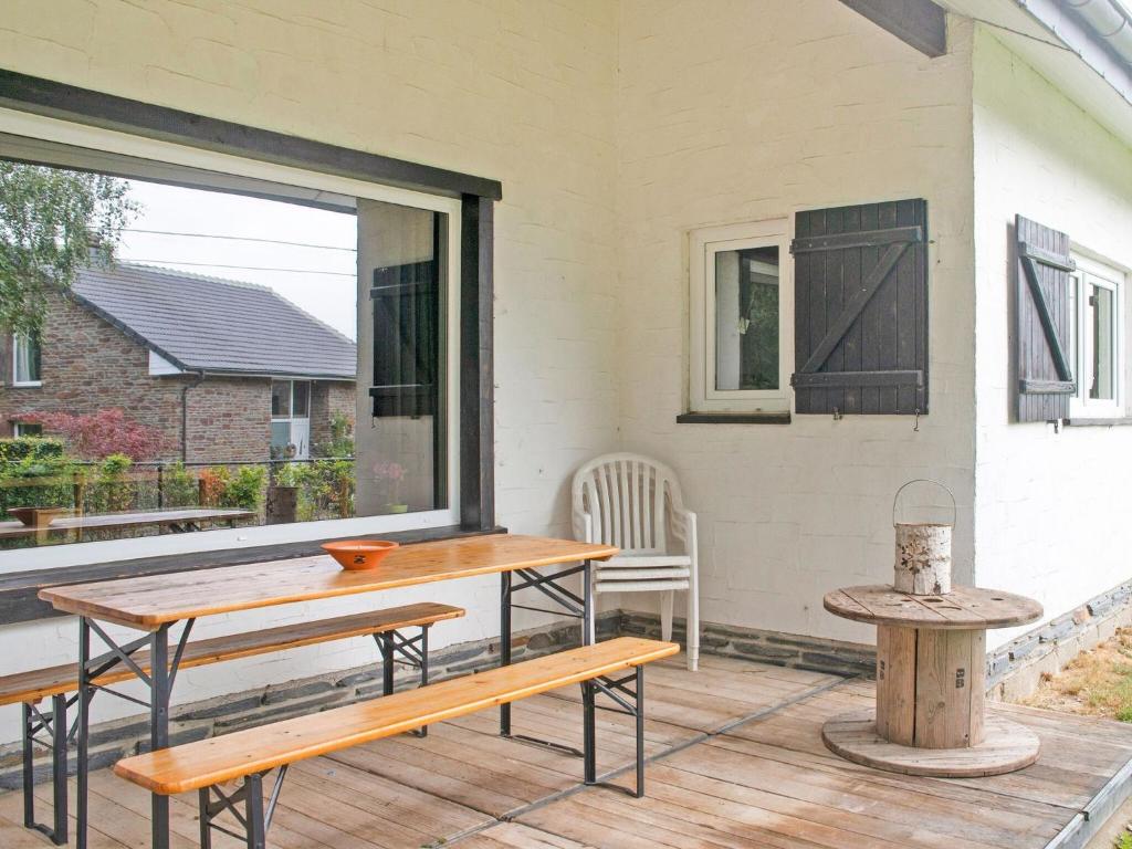 a patio with benches and a table and a window at Holiday Home between Spa and Eifel Nature Park in Xhoffraix