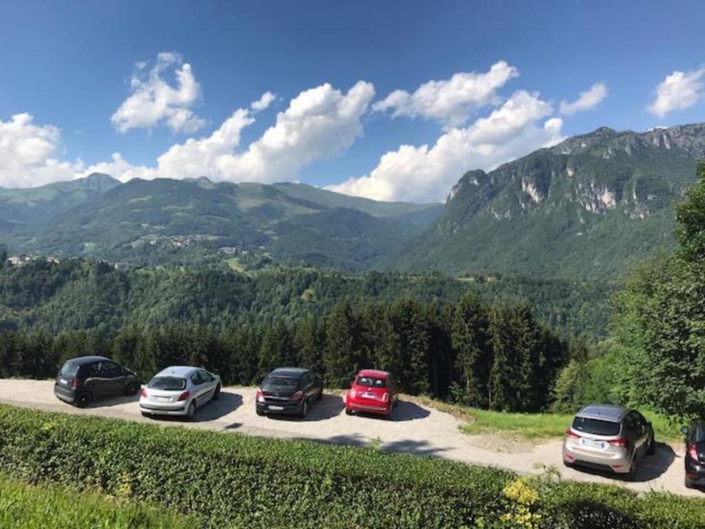 um grupo de carros estacionados num parque de estacionamento com montanhas em Val Taleggio nel verde x8 persone con camino e Wifi em Olda