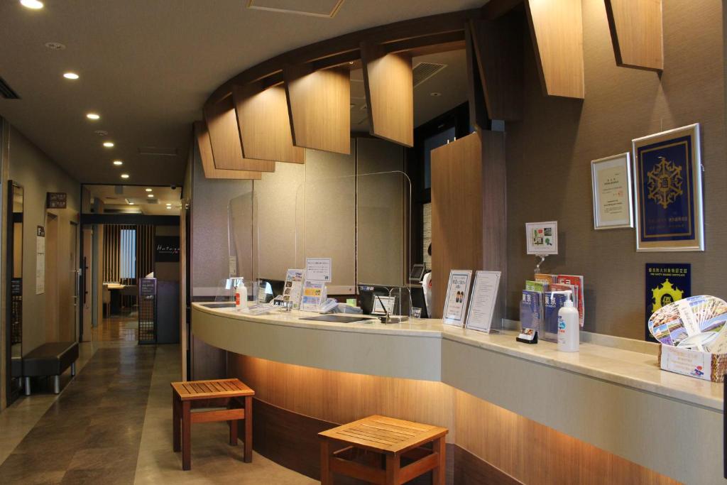 a restaurant with a counter and two stools in front of it at Dormy Inn Akihabara in Tokyo