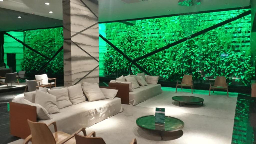 sala de estar con sofá blanco y pared verde en Time Home Service 1411, en Maceió