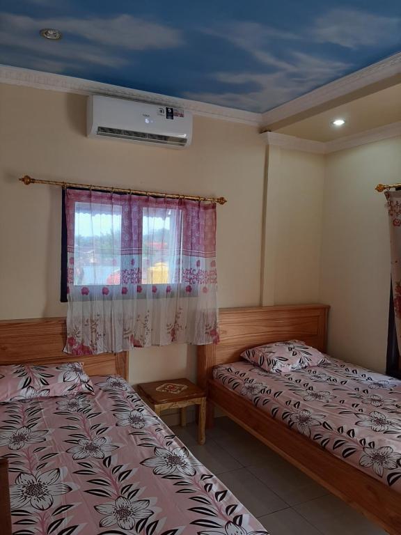 um quarto com 2 camas e uma janela em Blue Shark Divers Bunaken em Bunaken
