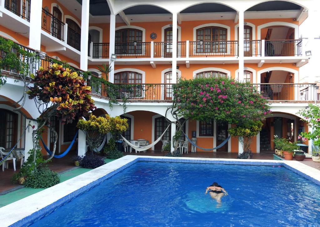 una persona en una piscina frente a un edificio en Don Luis Hostal - Sucursal Galeana - Tecolutla, en Tecolutla