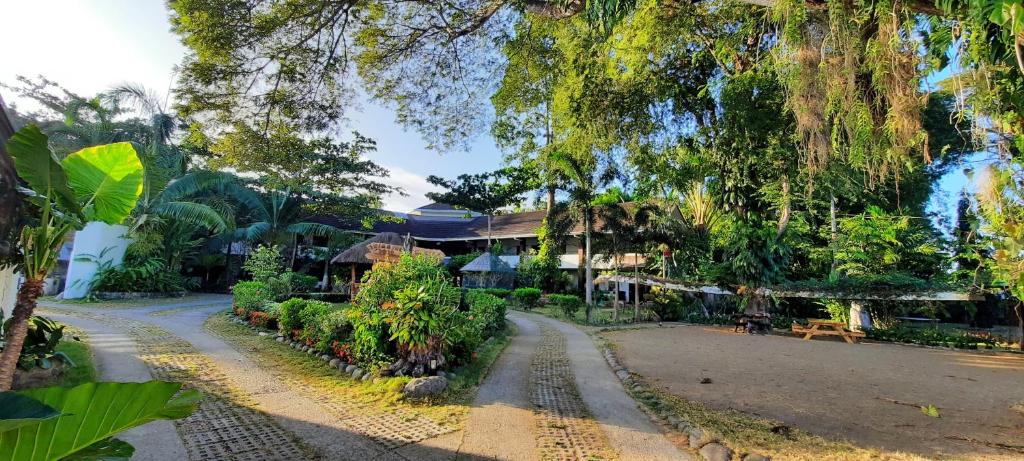 an empty road in front of a house with trees at Balay Tuko Garden Inn in Puerto Princesa City