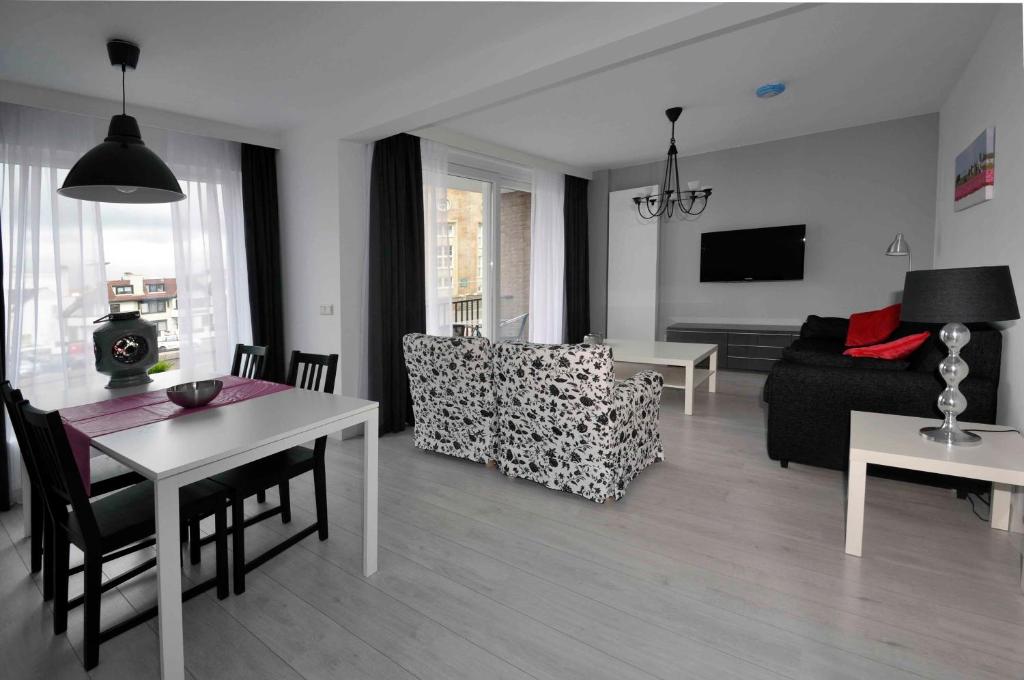 sala de estar con mesa y sofá en Schelvis Apartments, en Zandvoort