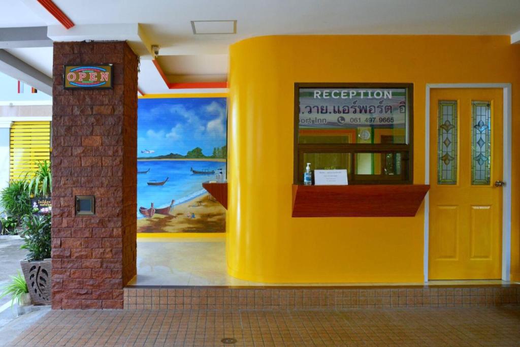 a yellow building with a painting on the wall at T.Y. Airport Inn in Nai Yang Beach