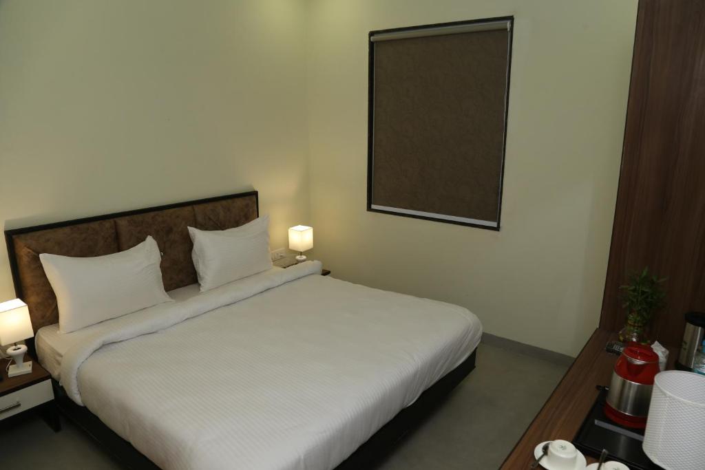 Postel nebo postele na pokoji v ubytování Vijay Vilas Hotel & Convention Hall