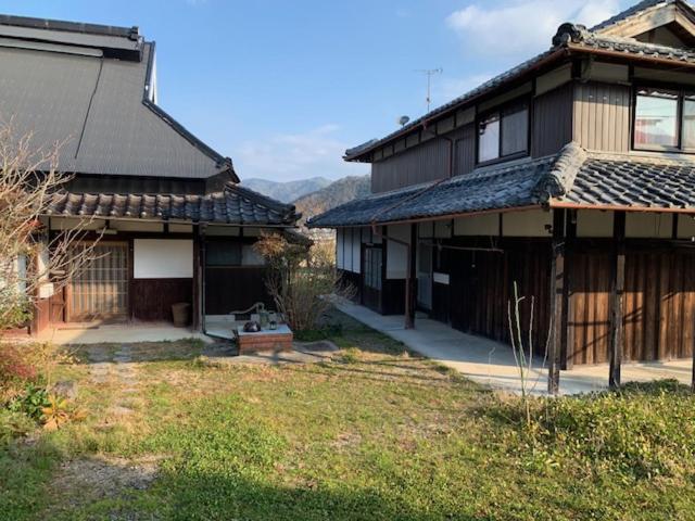 a house with a yard next to a building at 民泊はのこの庭 in Kokuryō
