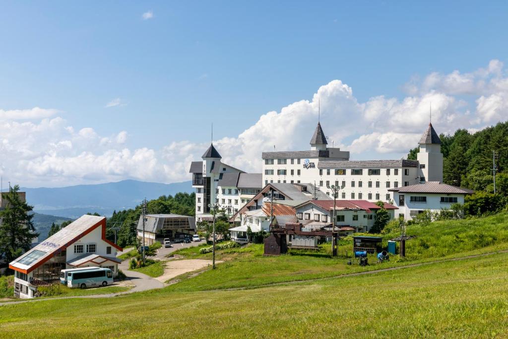 a large white building with tall towers on a hill at Hotel Tagawa in Yamanouchi