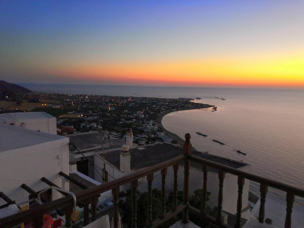 a view of the beach at sunset from a balcony at House in Skyros with an amazing sea view in Skiros