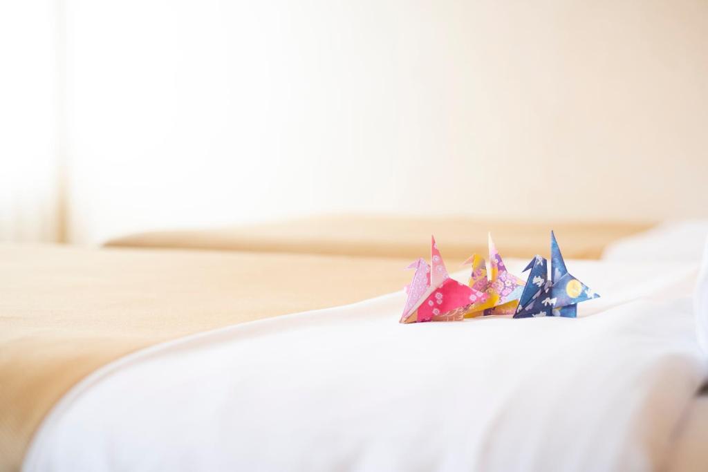 un paio di origami seduti sopra un letto di Valie Hotel Hiroshima a Hiroshima