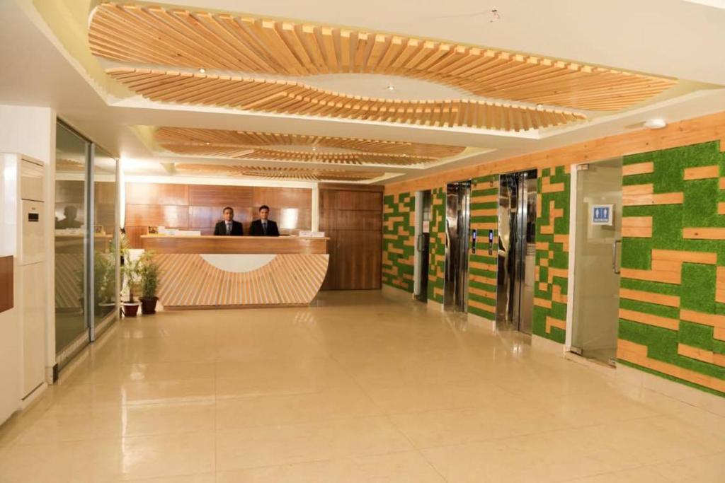 a lobby with two people sitting at a counter at Hotel Golden Hill in Cox's Bazar