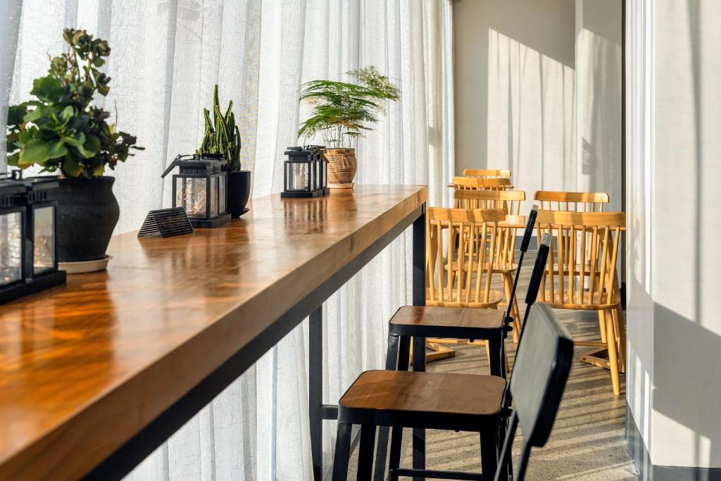 a bar in a room with chairs and plants at Whispering Mountains Boutique Hotel in Zhangjiajie