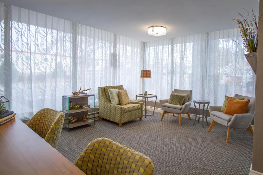 a living room with chairs and a table at Holiday Inn Bloomington Airport South-Mall Area by IHG in Bloomington