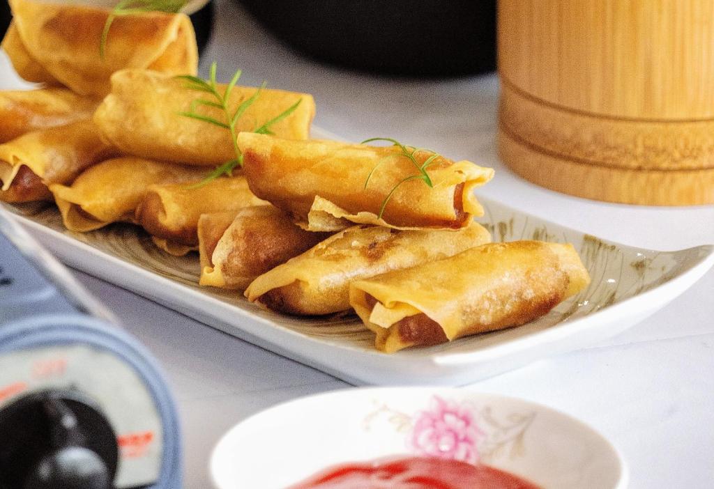 a plate of food with wontons on a table at Whispering Mountains Boutique Hotel in Zhangjiajie