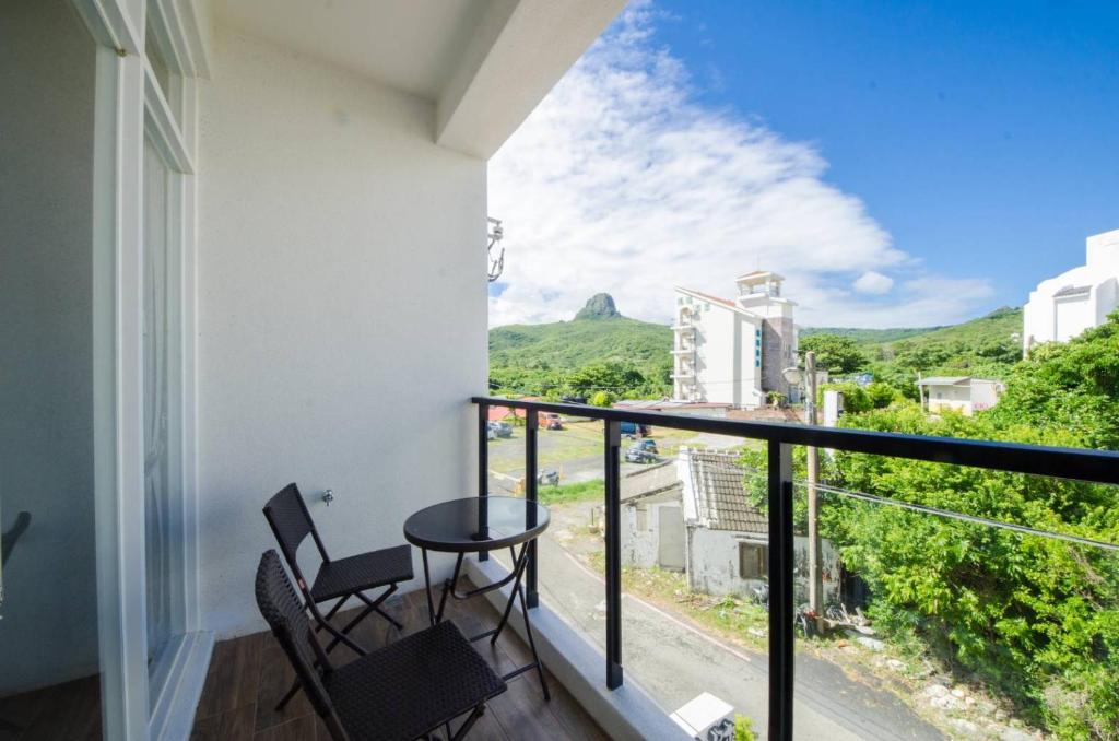 a balcony with two chairs and a table at 墾丁山風足跡 in Kenting