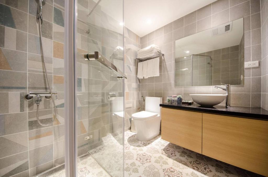 a bathroom with a shower and a toilet and a sink at 墾丁山風足跡 in Kenting
