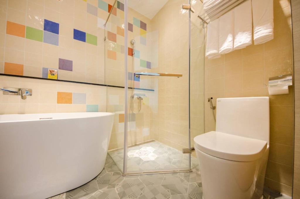 a bathroom with a toilet and a glass shower at 墾丁山風足跡 in Kenting