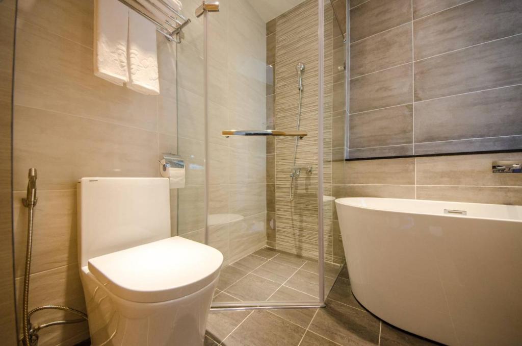 a bathroom with a toilet and a glass shower at 墾丁山風足跡 in Kenting