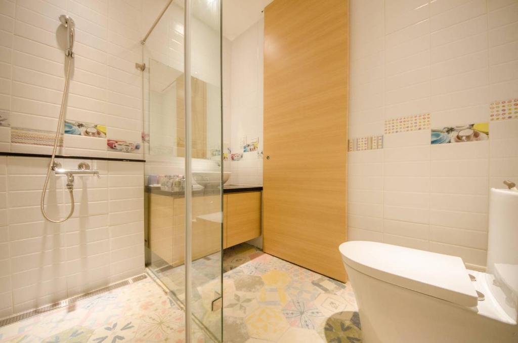 a bathroom with a toilet and a glass shower at 墾丁山風足跡 in Kenting
