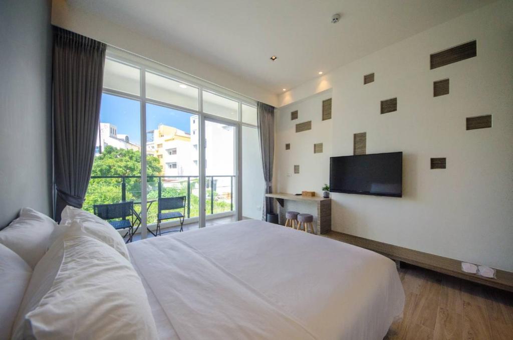 a bedroom with a large bed and a large window at 墾丁山風足跡 in Kenting