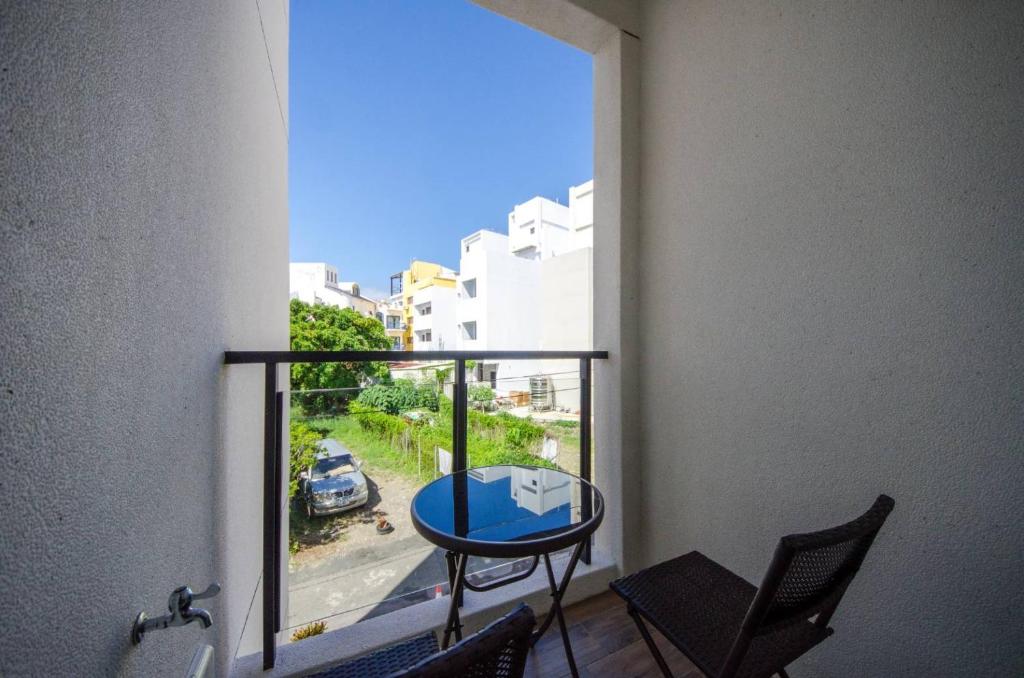 a balcony with a table and chairs and a window at 墾丁山風足跡 in Kenting