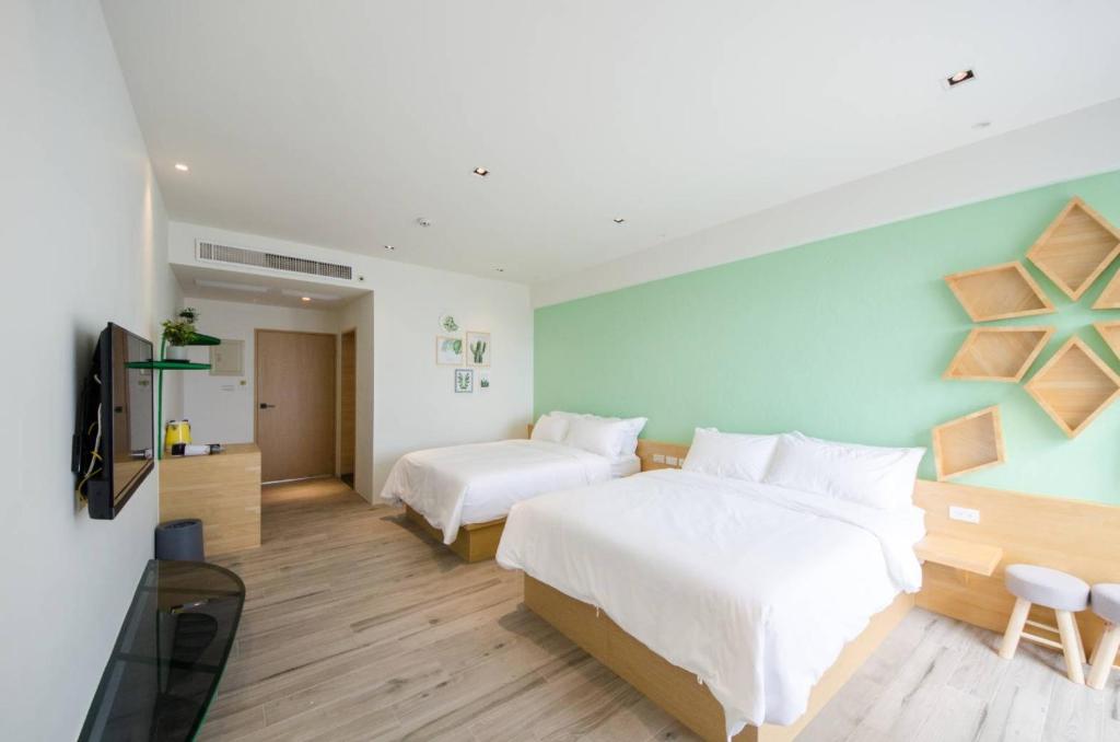a hotel room with two beds and a television at 墾丁山風足跡 in Kenting