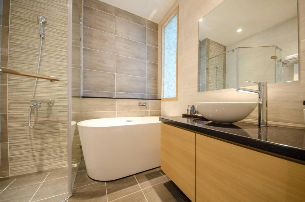 a bathroom with a sink and a toilet and a tub at 墾丁山風足跡 in Kenting