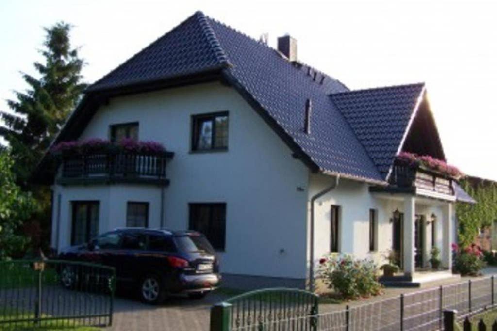 een auto geparkeerd voor een wit huis bij Ferienhaus Eichhörnchen am Fleesensee in Göhren-Lebbin