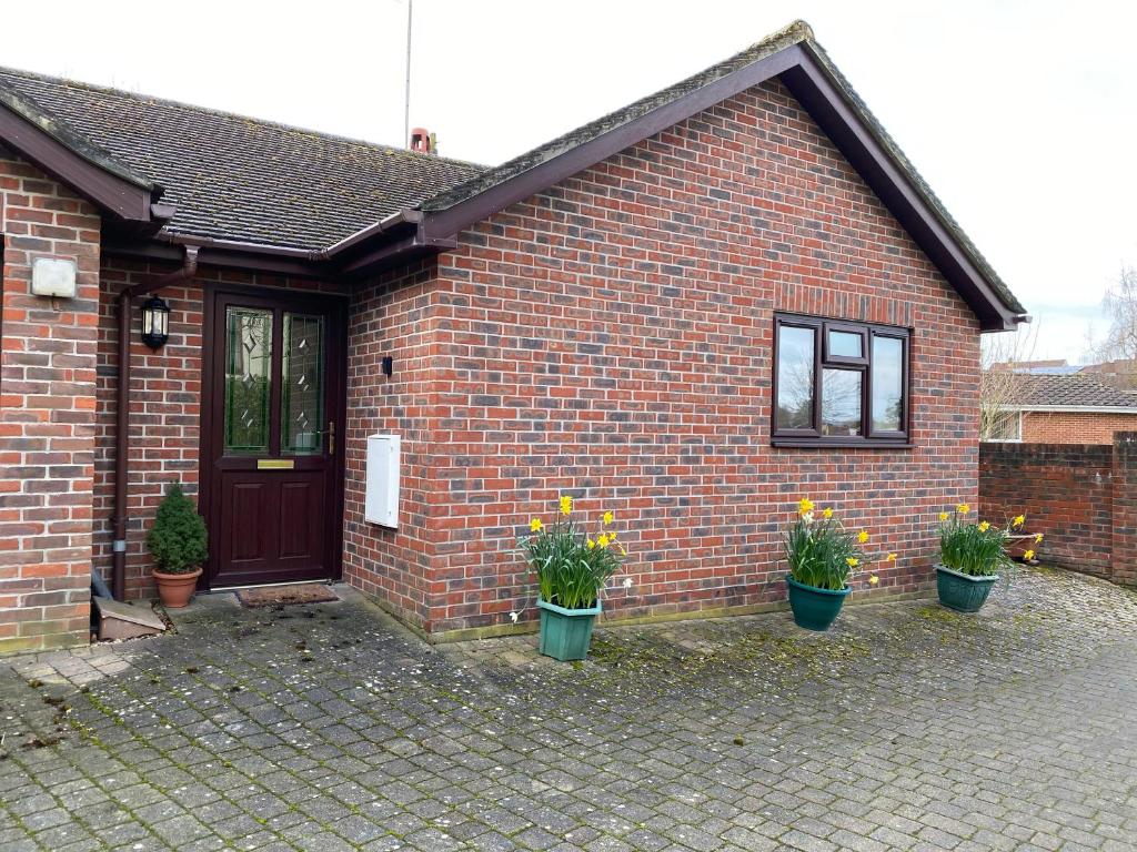 a brick house with potted plants in front of it at The Oaks in Warminster