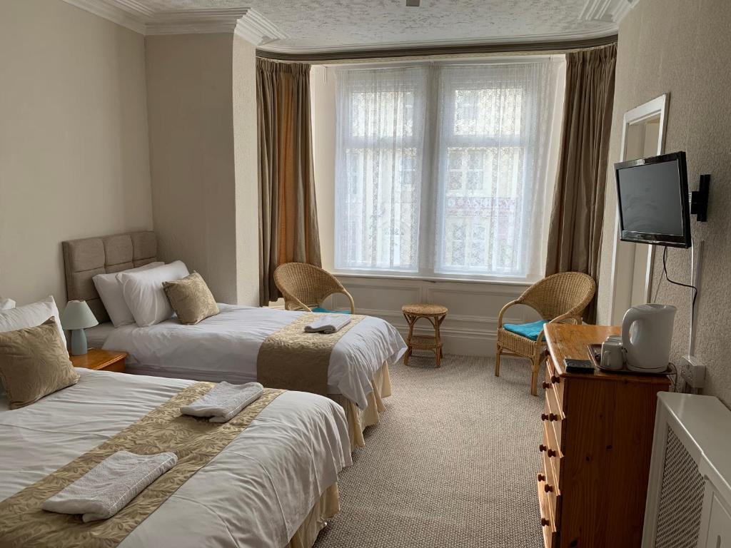 ブラックプールにあるSharn Bek Hotelのベッド2台とテレビが備わるホテルルームです。