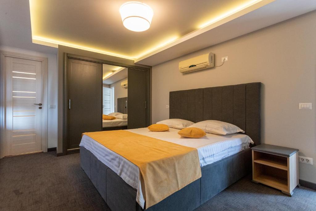 sypialnia z dużym łóżkiem z pomarańczowymi poduszkami w obiekcie Corso Apartments B&B w mieście Fokszany