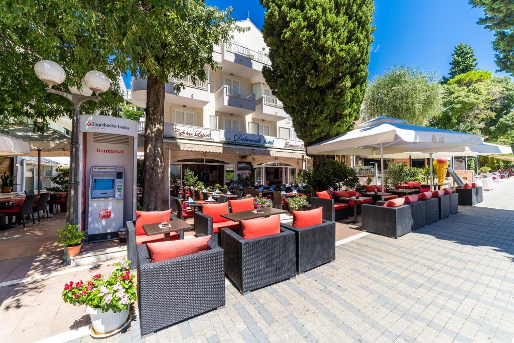 a patio with tables and chairs and umbrellas at Hotel Dubrovnik in Dubrovnik