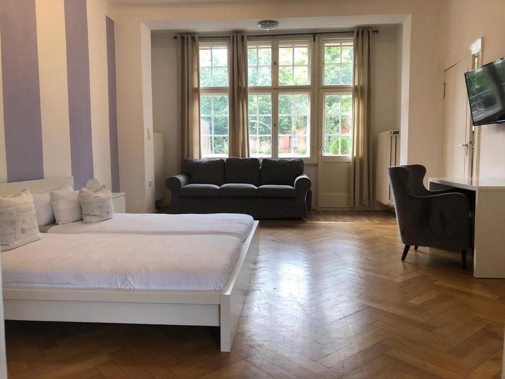 a bedroom with a bed and a couch and a piano at Ela Apartments Berlin in Berlin