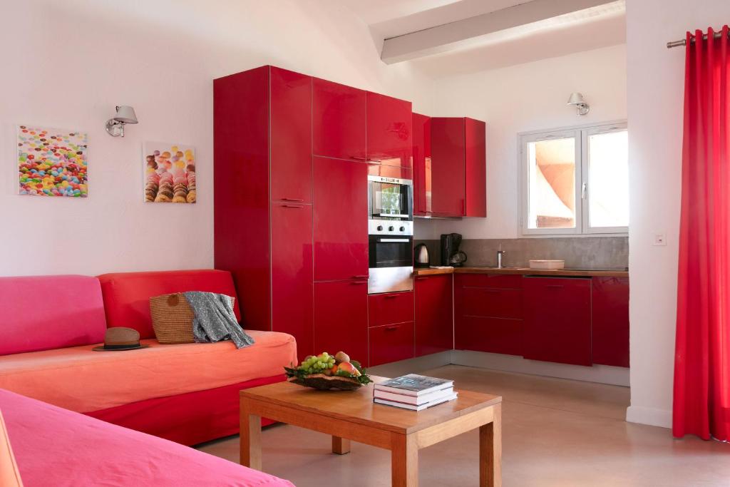 a living room with red cabinets and a table at Domaine Santa Giulia Palace in Porto-Vecchio
