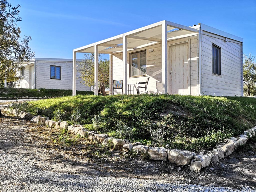 a small house on top of a grassy hill at Mennuli&Alivi - Organic Farm in Noto