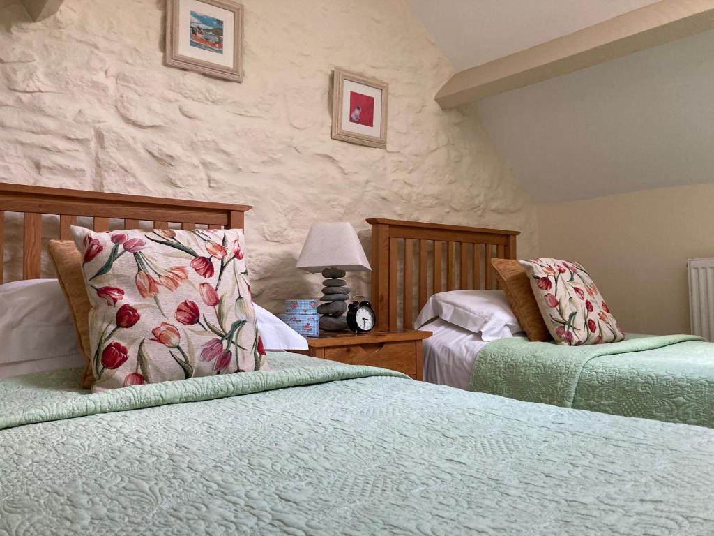 a bedroom with two beds and a lamp on a table at Courtyard Apartment in Shepton Mallet