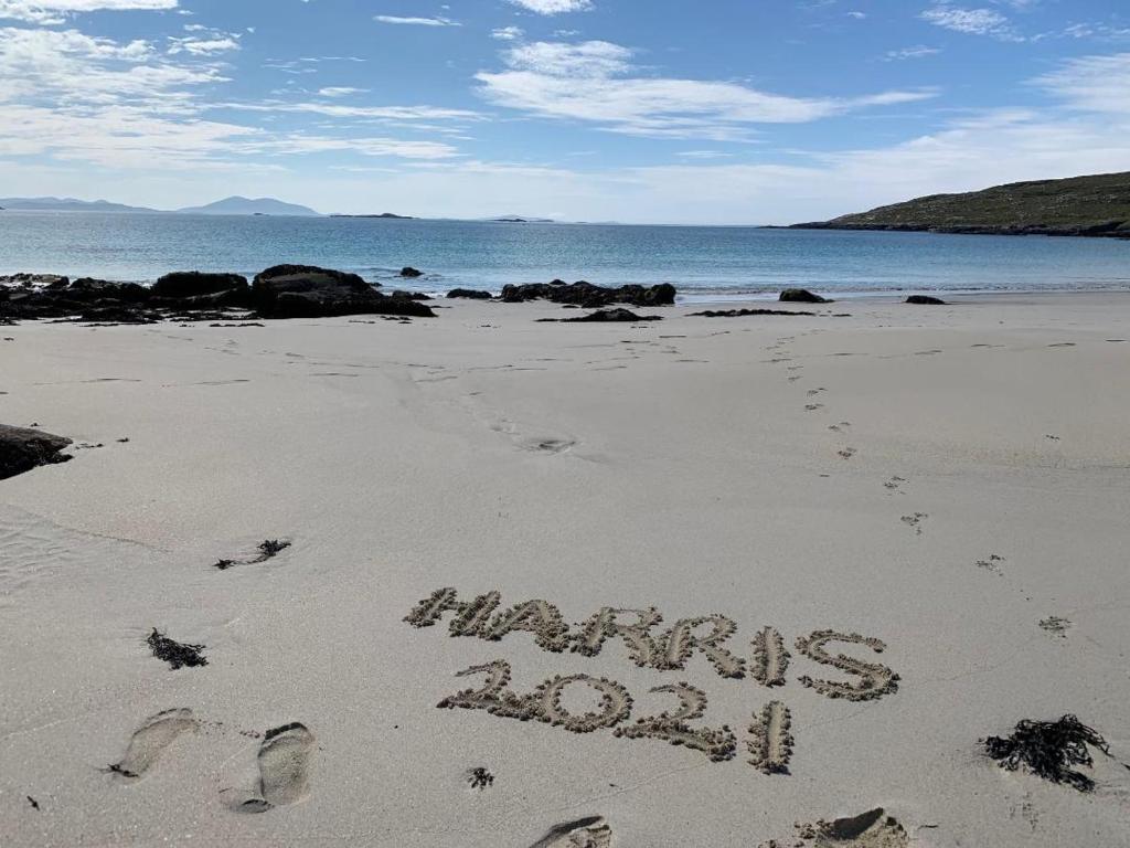 a sign written in the sand on a beach at George's House - 1 Leacklee in Manish