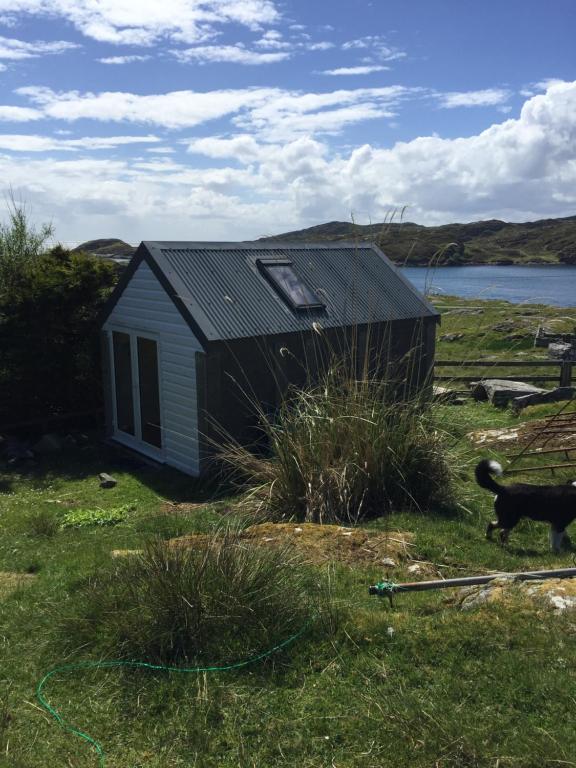 a small house in a field next to a body of water at George's House - 1 Leacklee in Manish