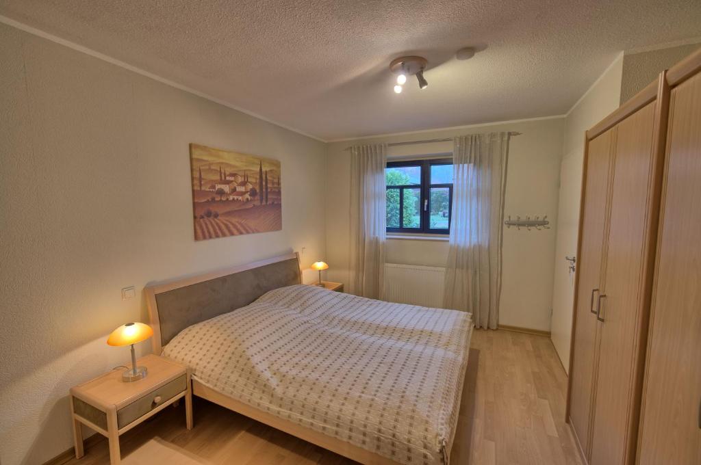 um quarto com uma cama, uma janela e 2 candeeiros em Ferienwohnung Wittrock em Bad Bentheim