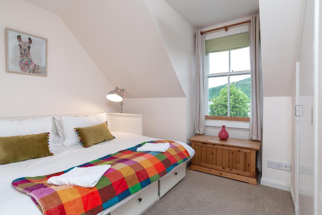 a bedroom with two beds and a window at Historic Village, Rare Find, Amazing Views in Ballater