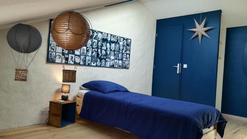 1 dormitorio con 1 cama azul y puerta azul en Un nid pour la nuit, Chambres d’hôtes, en Saint-Géry